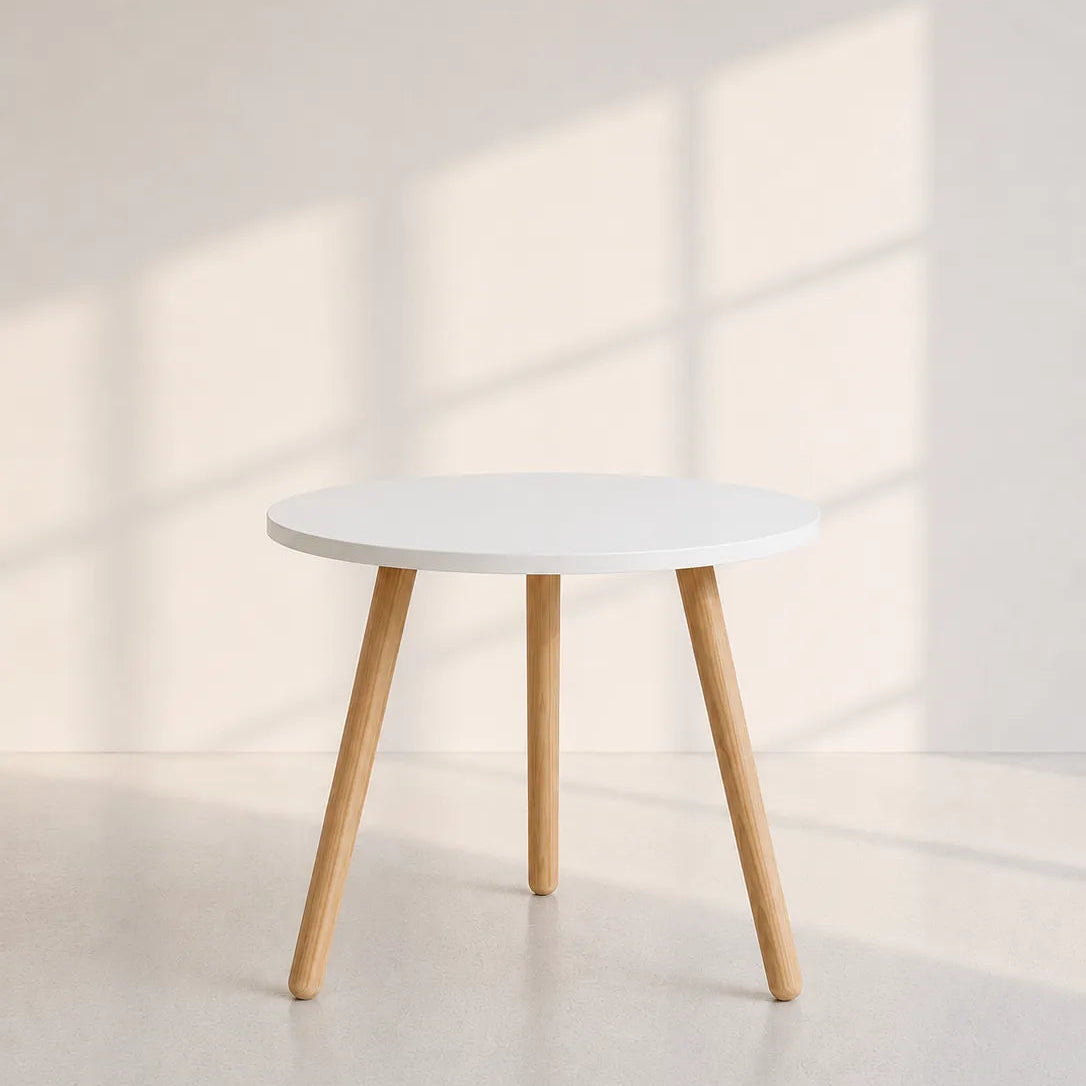 Image of A minimalist round side table with a white top and light natural wood legs, set against a warm beige wall with soft window shadow patterns.