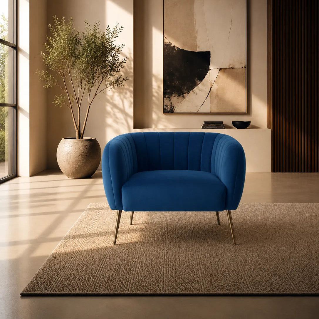 Image of A modern blue upholstered accent chair with slim metal legs, placed on a textured beige rug in a sunlit contemporary interior with a potted plant, wall art, and warm ambient lighting.
