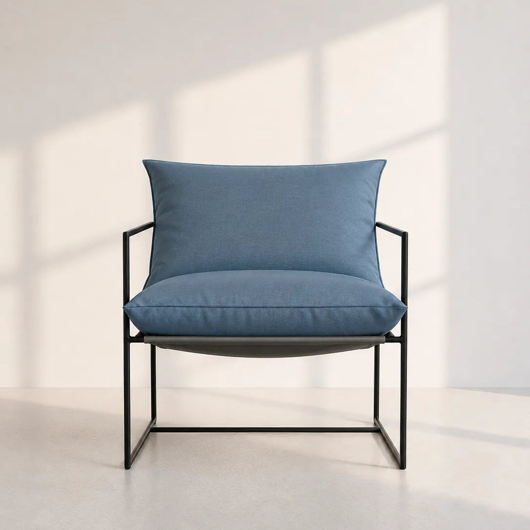 Image of A modern outdoor lounge chair with a blue cushioned seat and backrest, supported by a slim black metal frame, set against a minimalist off-white wall with soft window shadow patterns.