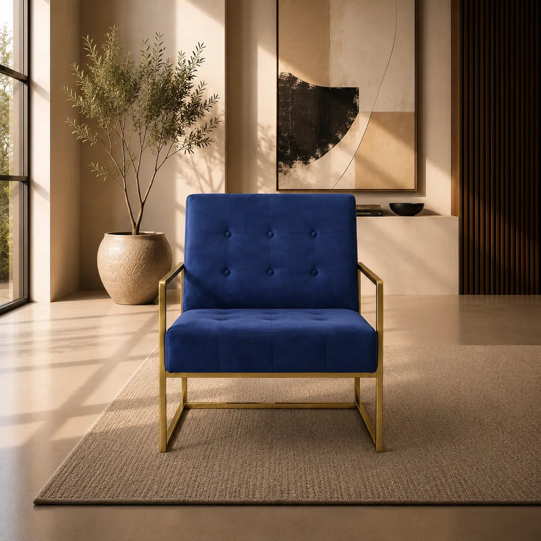 Image of A modern blue velvet armchair with a gold metal frame, positioned in a stylishly decorated room with warm lighting, a potted plant, and abstract wall art.