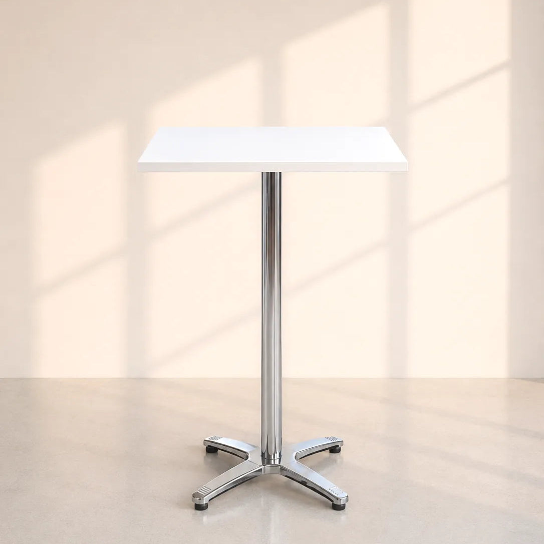 Image of A modern square bar table with a white top and a polished chrome pedestal base, set against a warm beige wall with soft window shadow projections.