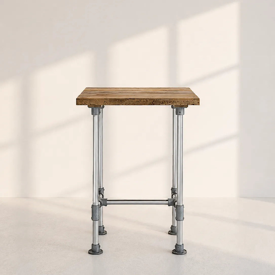 Image of A rustic industrial-style table featuring a square weathered brown wooden top supported by a silver metal frame with adjustable legs, set against a minimalist off-white wall with soft window shadow projections.