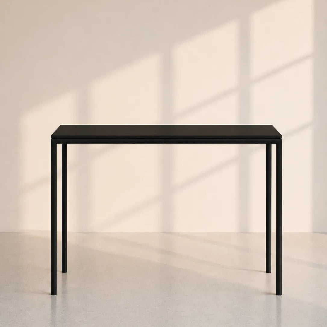 Image of A minimalist black metal console table with a rectangular top and slim legs, set against a warm beige wall with soft window shadow patterns.