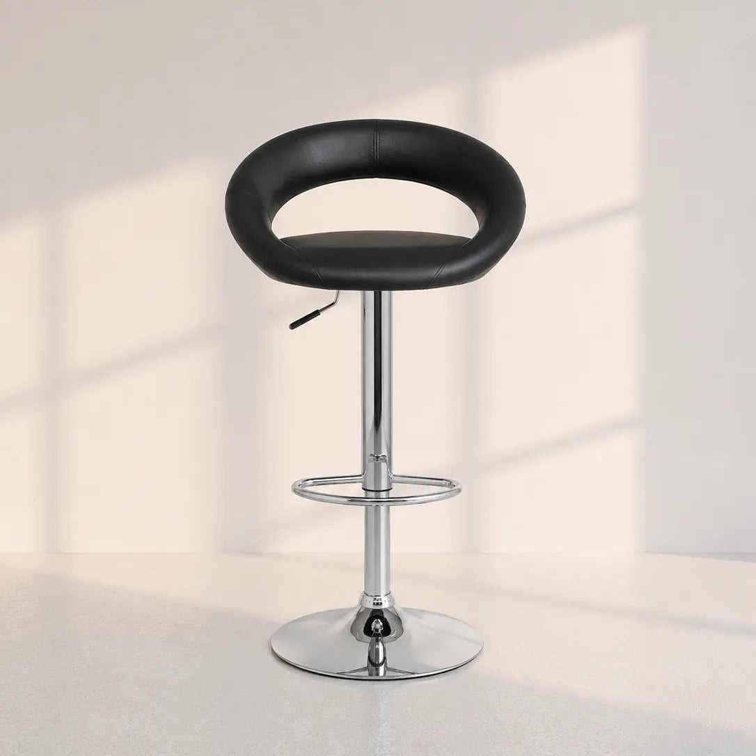 Image of A modern bar stool with a black curved seat and a polished chrome pedestal base, set against a minimalist off-white wall with soft window shadow patterns.